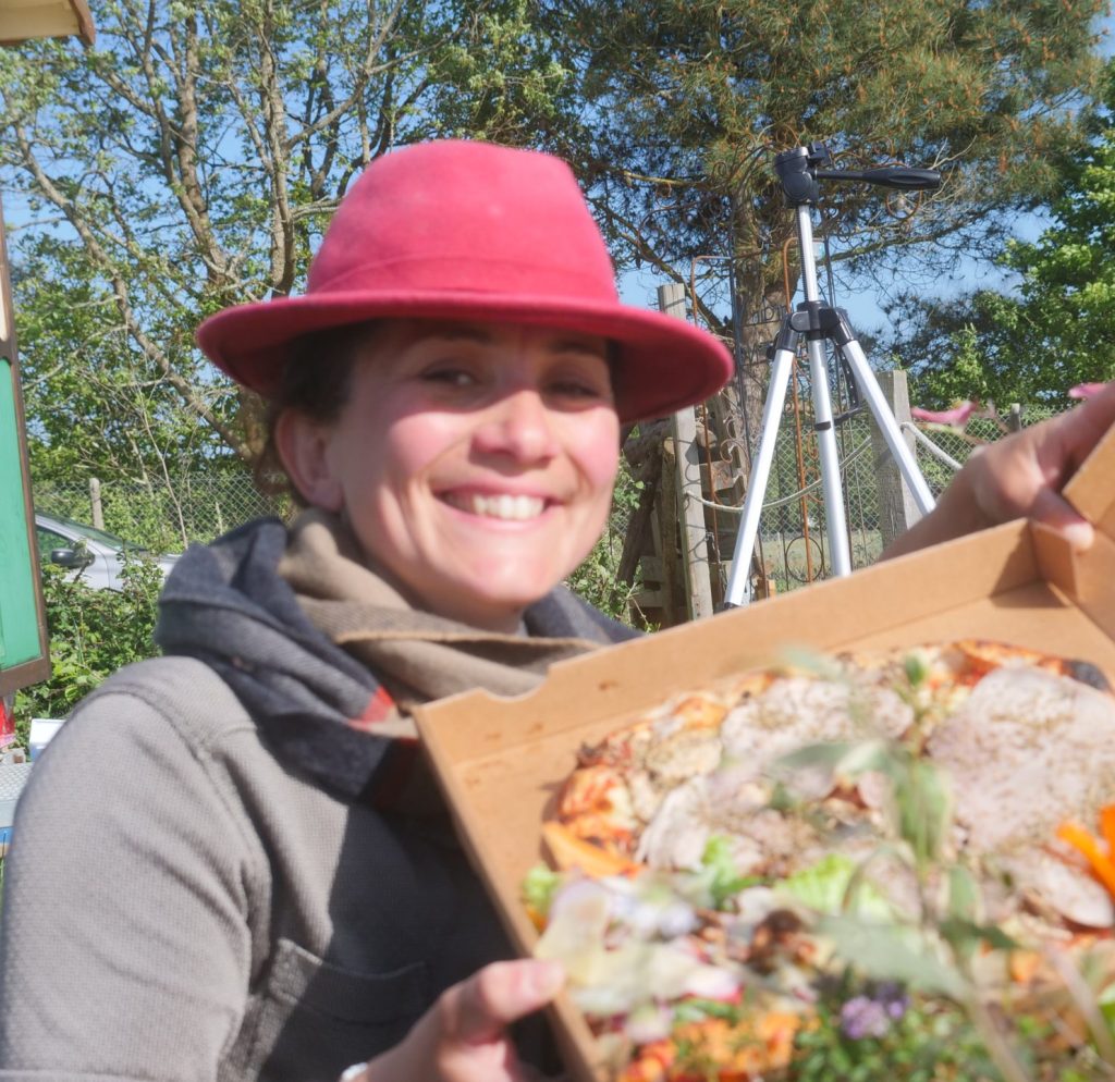Photo d'Audrey qui montre une de ses pizzas avec fierté et un sourire " jusqu'aux oreilles"