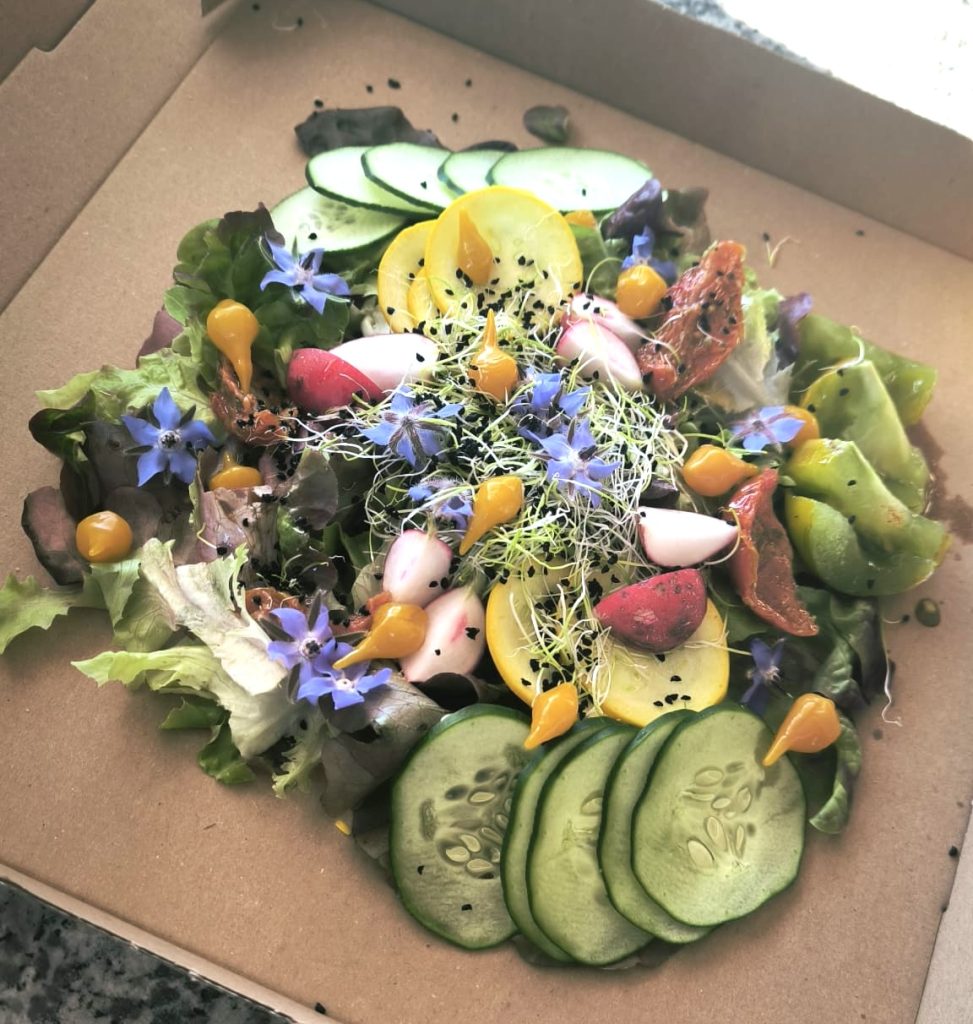 Pizza végétarienne avec ses crudités dont fleurs comestibles